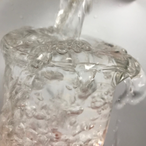 Water overflowing a glass.